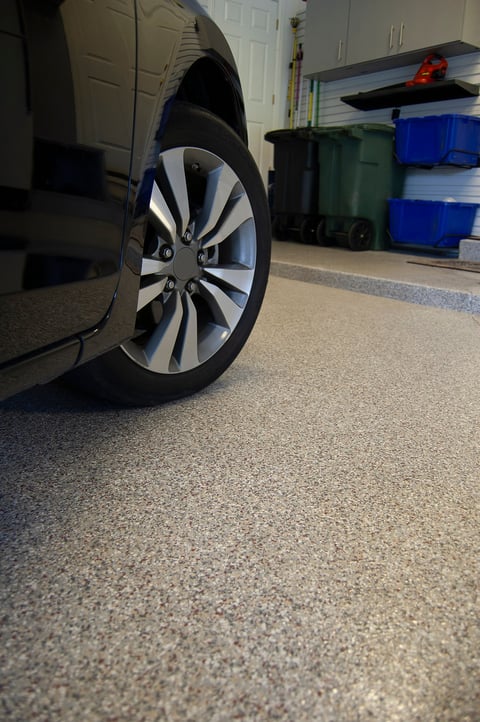 Epoxy garage floor coating with car tire visible