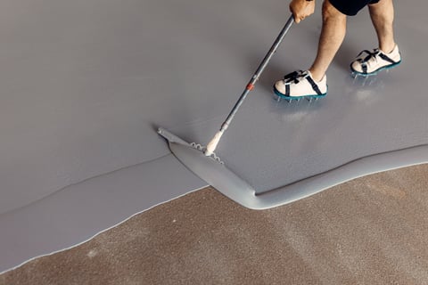 Construction worker applying grey epoxy resin