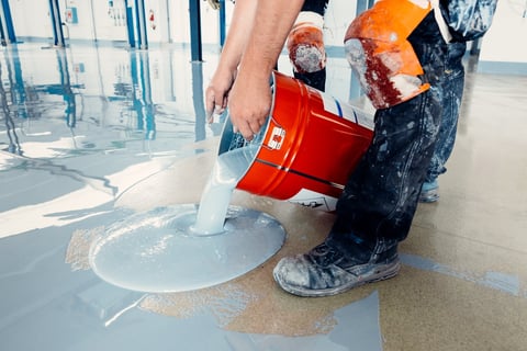 Construction workers applying epoxy flooring